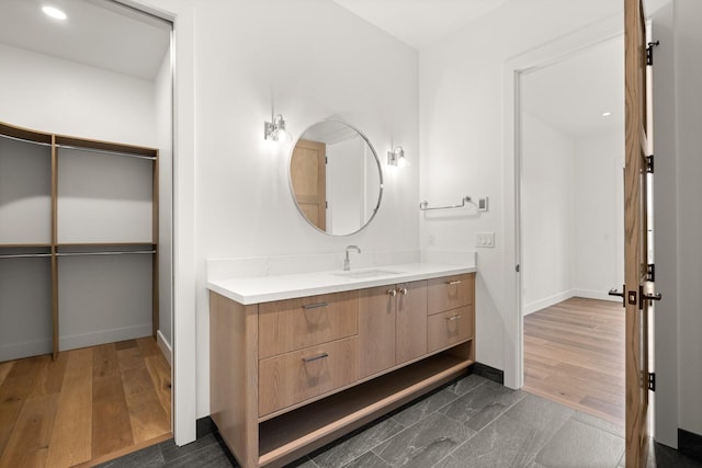 bathroom with vanity, baseboards, and wood finished floors