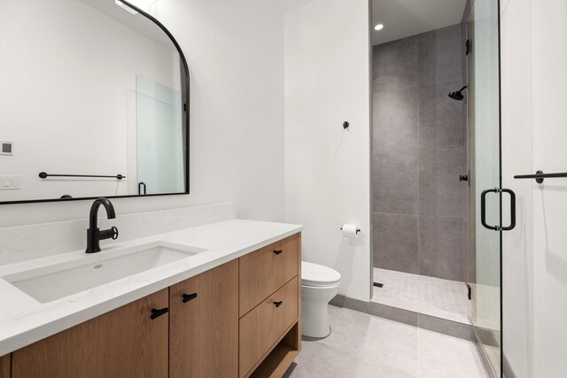 bathroom featuring vanity, tile patterned flooring, a stall shower, and toilet