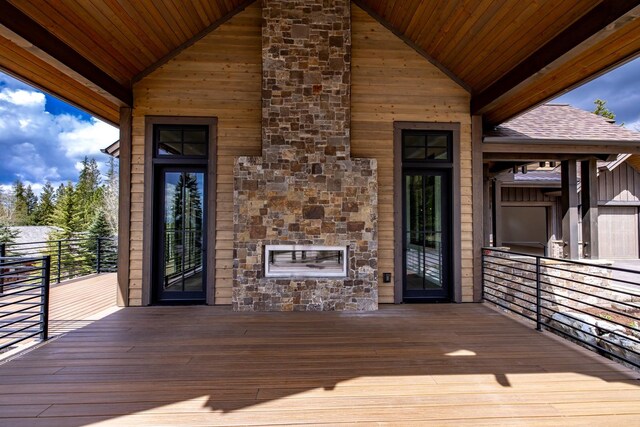 deck featuring an outdoor stone fireplace