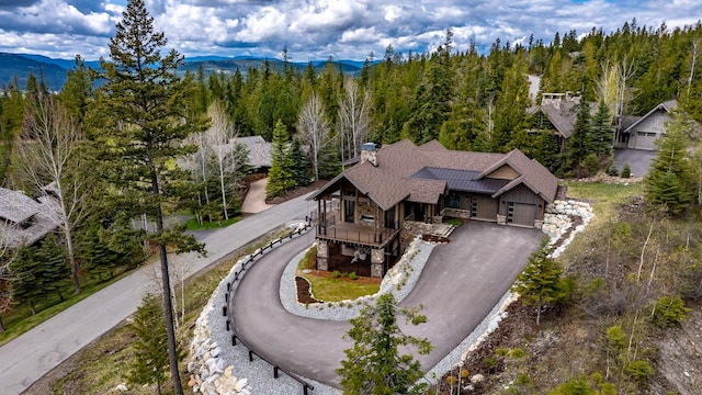 birds eye view of property featuring a view of trees and a mountain view