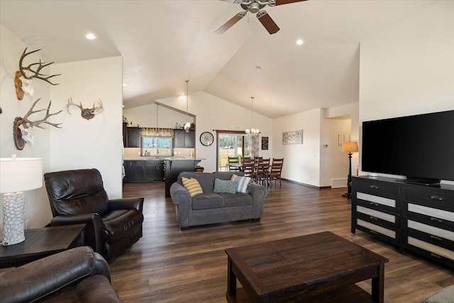 living room with dark wood-style flooring, high vaulted ceiling, and ceiling fan with notable chandelier