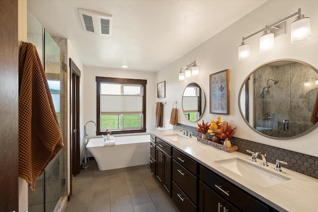 full bath featuring a sink, tile patterned floors, a shower stall, and visible vents