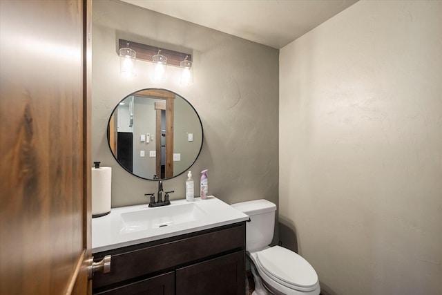 half bathroom featuring toilet and vanity