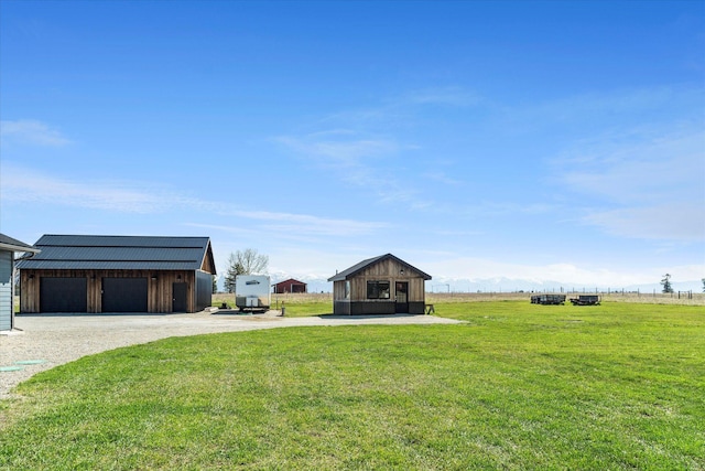 view of yard featuring a detached garage and an outdoor structure