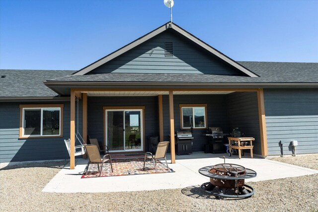 2449 Airport Rd, Kalispell, MT 59901 - rear view of property featuring a fire pit, a patio area, and roof with shingles