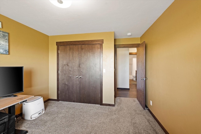 carpeted bedroom featuring baseboards and a closet