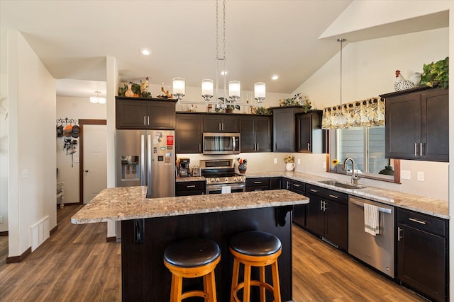 kitchen featuring a kitchen island, visible vents, appliances with stainless steel finishes, a sink, and lofted ceiling