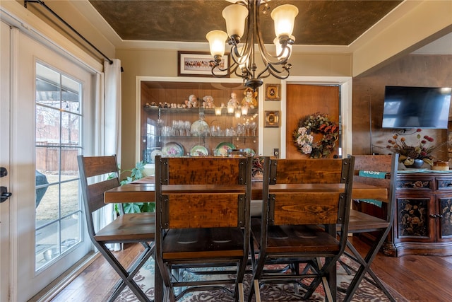 dining space with wood finished floors and a chandelier