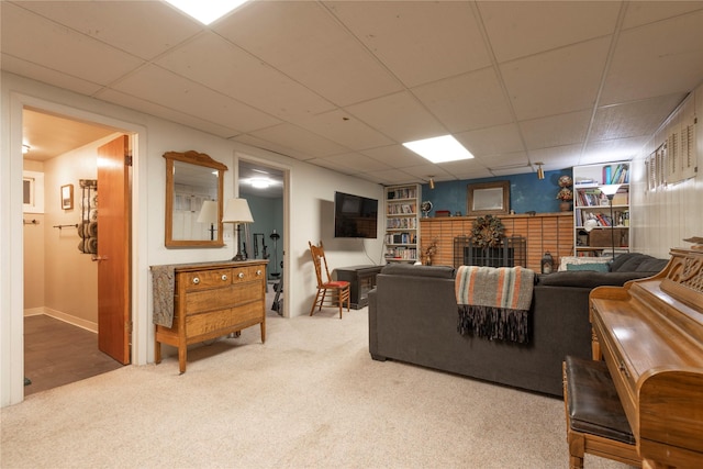 carpeted living room featuring a drop ceiling and a fireplace