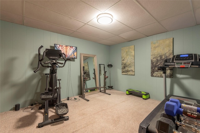 exercise area with a decorative wall, carpet flooring, and a drop ceiling