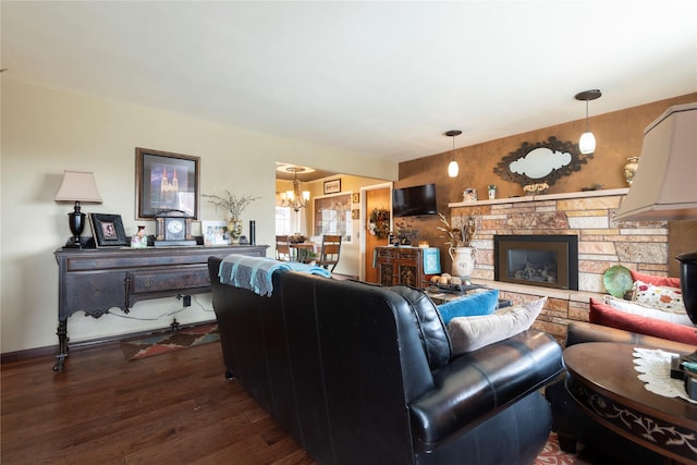 living room with a chandelier, dark wood finished floors, and a fireplace