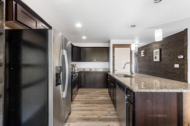 1521 Cheery Dr, Belgrade, MT 59714 - kitchen featuring appliances with stainless steel finishes, a center island with sink, dark brown cabinets, a sink, and light wood-style flooring