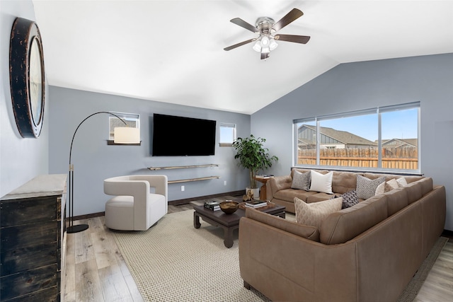 1521 Cheery Dr, Belgrade, MT 59714 - living room featuring vaulted ceiling, baseboards, a ceiling fan, and light wood-style flooring
