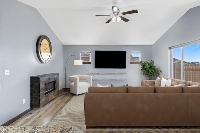 1521 Cheery Dr, Belgrade, MT 59714 - living room with a glass covered fireplace, baseboards, a ceiling fan, light wood-style flooring, and vaulted ceiling