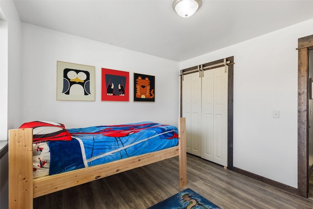 1521 Cheery Dr, Belgrade, MT 59714 - bedroom featuring baseboards, a barn door, and wood finished floors