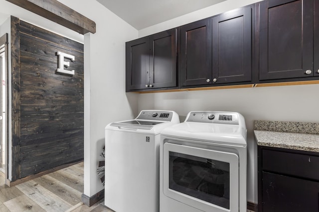 1521 Cheery Dr, Belgrade, MT 59714 - washroom featuring separate washer and dryer, cabinet space, and light wood-type flooring