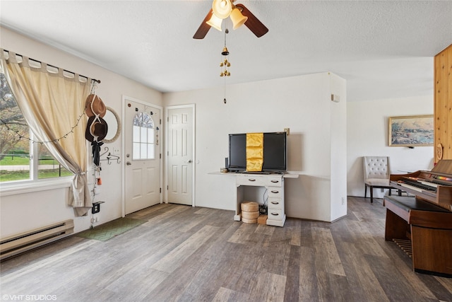 living area with a ceiling fan, a baseboard heating unit, and wood finished floors
