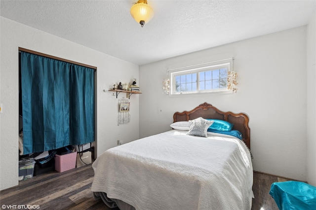 bedroom with a textured ceiling and wood finished floors