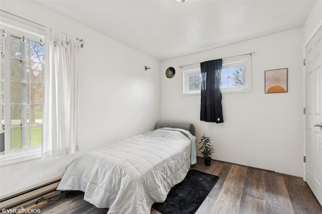 bedroom with a baseboard radiator and wood finished floors