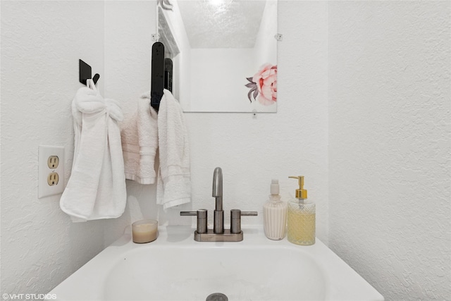 bathroom featuring a textured wall and a sink