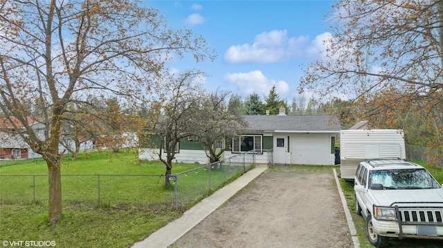 ranch-style house featuring driveway, fence private yard, and a front lawn