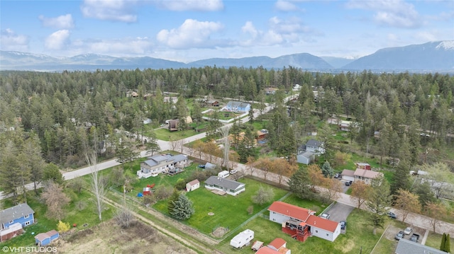 birds eye view of property with a mountain view and a forest view