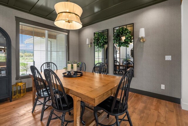 dining space featuring baseboards and light wood-type flooring