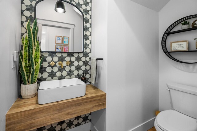 bathroom featuring backsplash and toilet