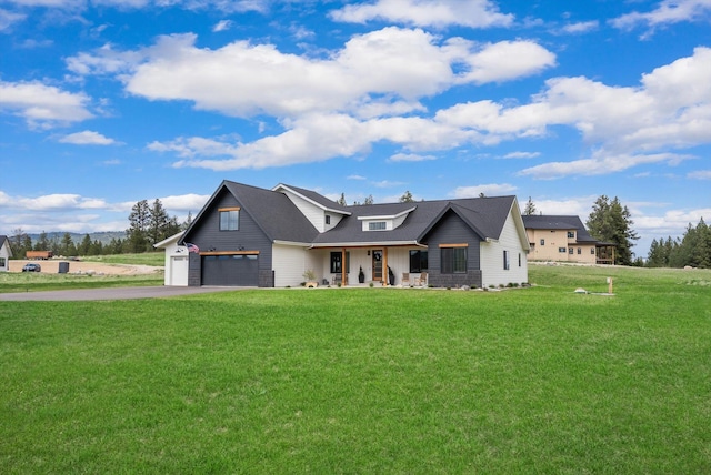 modern farmhouse style home with a porch, a front lawn, and aphalt driveway