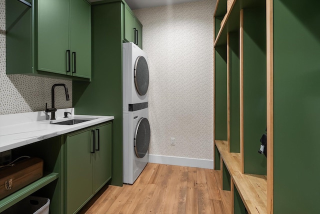1007 Pheasant Ridge Dr, Kalispell, MT 59901 - laundry room with stacked washing machine and dryer, cabinet space, and light wood-type flooring