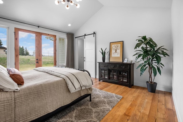 bedroom featuring french doors, access to exterior, vaulted ceiling, wood finished floors, and a barn door