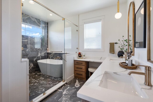 full bath featuring recessed lighting, a freestanding tub, marble finish floor, and vanity