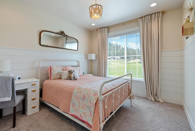 bedroom with wainscoting, light carpet, and multiple windows