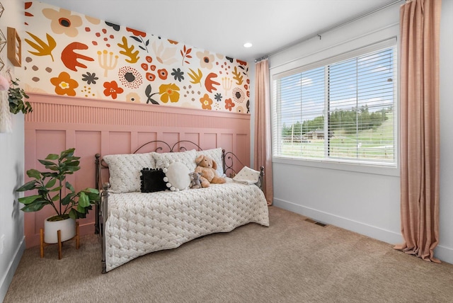 bedroom with wallpapered walls, visible vents, wainscoting, and carpet