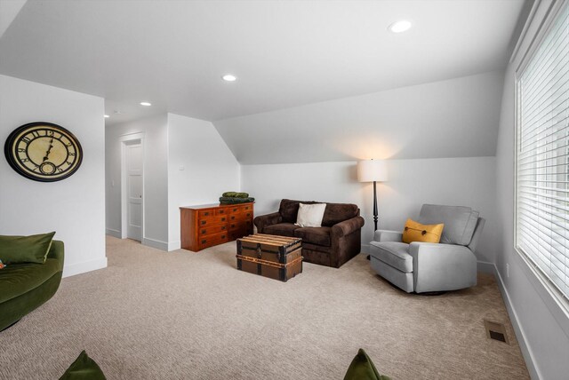 carpeted living room with a healthy amount of sunlight, vaulted ceiling, recessed lighting, and visible vents