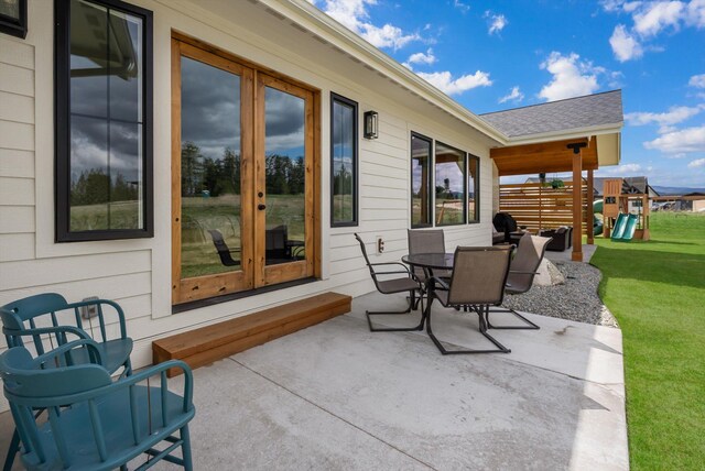 view of patio / terrace with outdoor dining area, a playground, and french doors