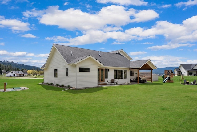 1007 Pheasant Ridge Dr, Kalispell, MT 59901 - rear view of property featuring a patio, a playground, a lawn, a mountain view, and a shingled roof