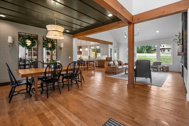 dining space featuring vaulted ceiling with beams and light wood-style floors