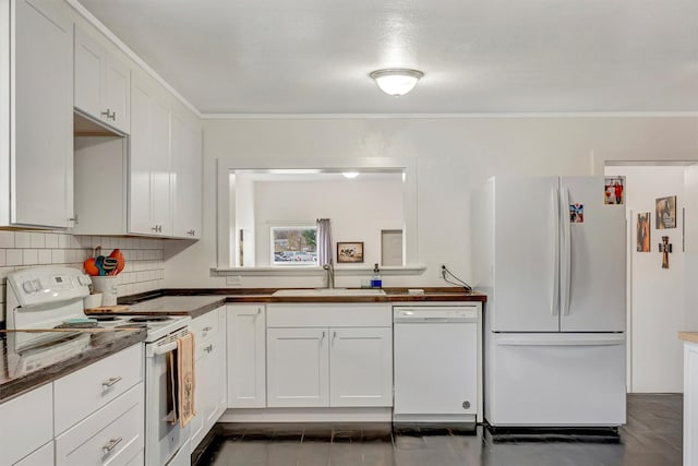 kitchen featuring crown molding, tasteful backsplash, a sink, white appliances, and white cabinetry
