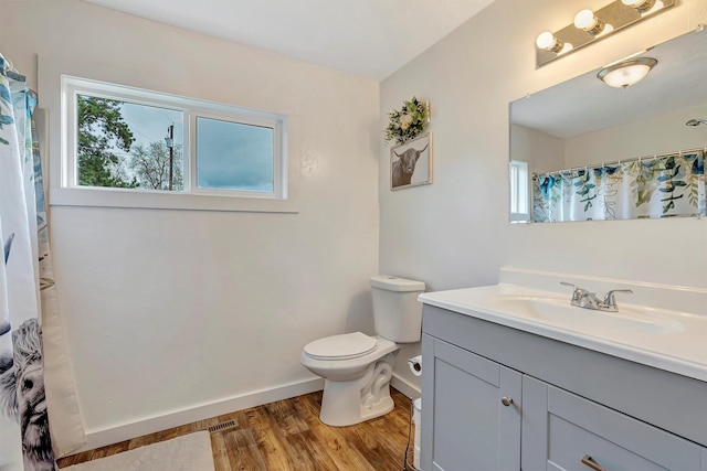 bathroom with wood finished floors, baseboards, vanity, toilet, and a shower with shower curtain