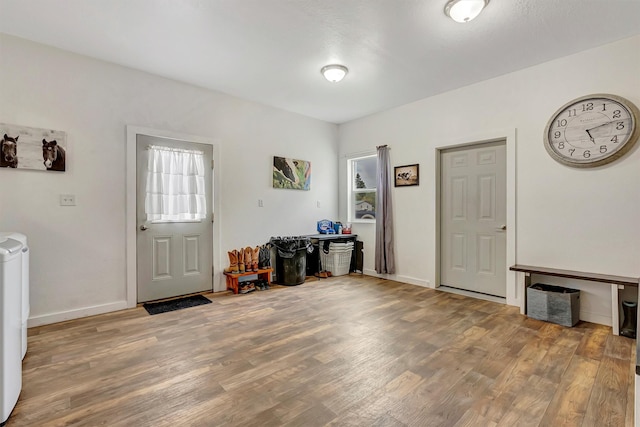 entryway featuring baseboards and wood finished floors