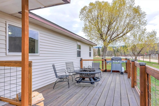 wooden deck with a grill and an outdoor fire pit