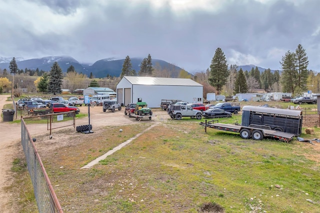 view of yard with fence, an outbuilding, and a mountain view