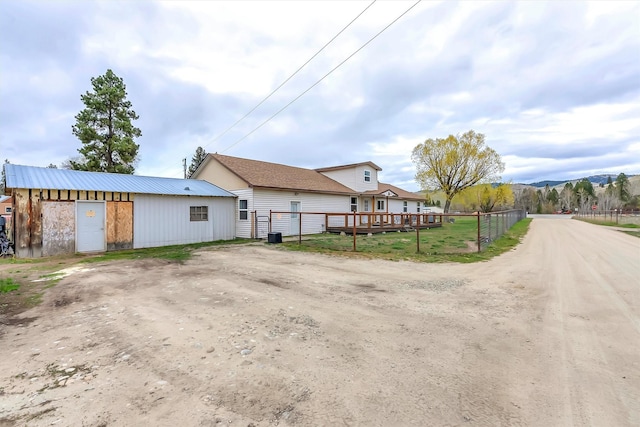 exterior space with dirt driveway and fence