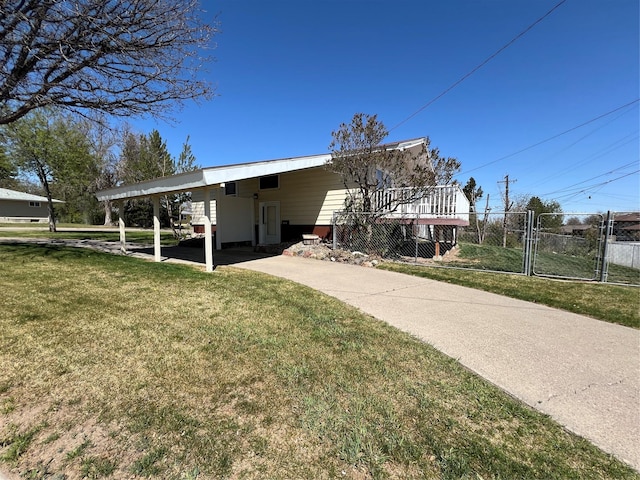view of home's exterior featuring driveway, a gate, fence, a yard, and an attached carport