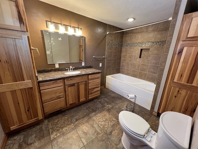 bathroom featuring vanity, tub / shower combination, and toilet