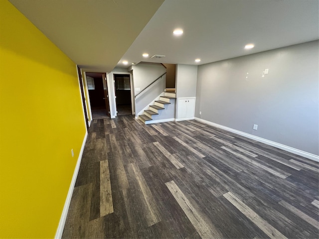 finished basement featuring stairway, baseboards, recessed lighting, and dark wood finished floors