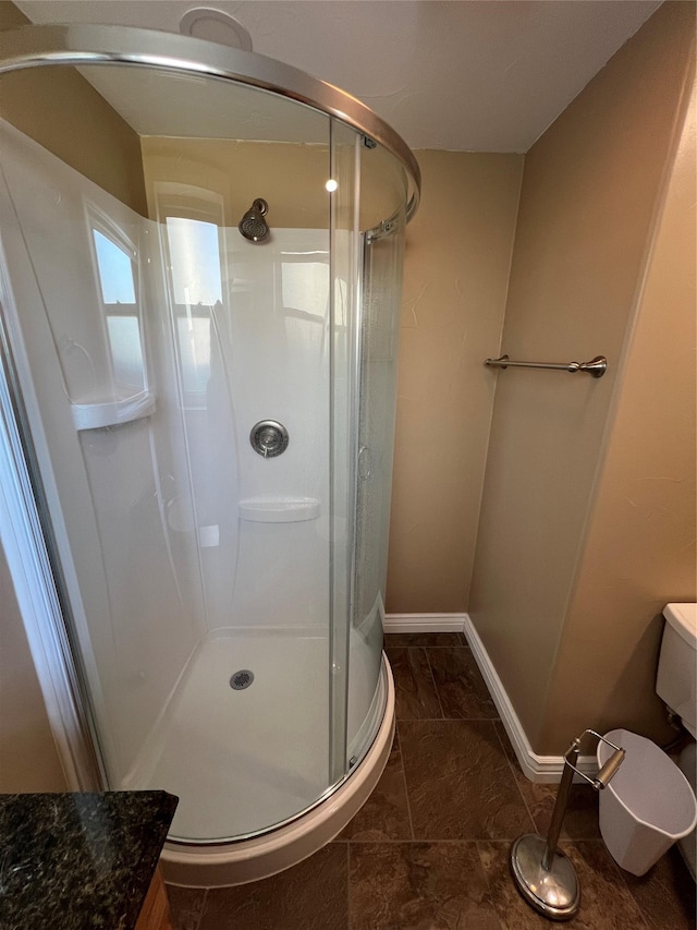 bathroom featuring baseboards and a stall shower