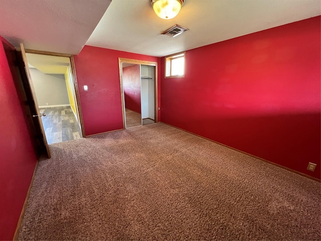 unfurnished bedroom featuring carpet floors, visible vents, and a closet