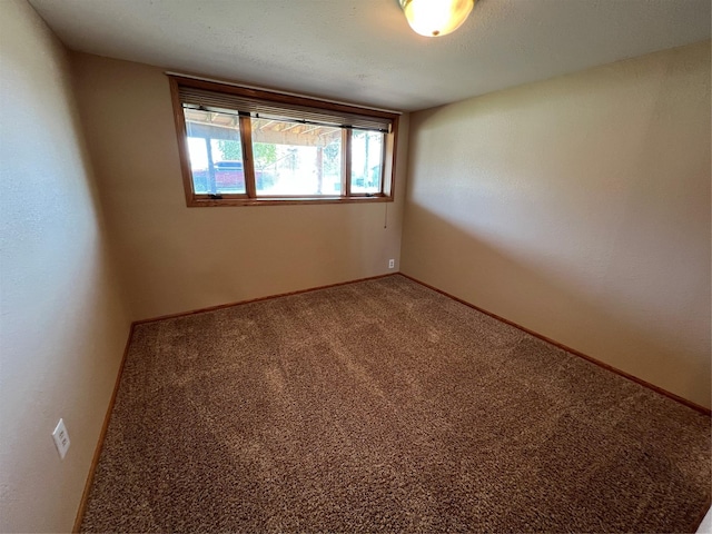 unfurnished room with baseboards and carpet